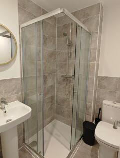 Modern bathroom featuring a clean, glass-enclos...
