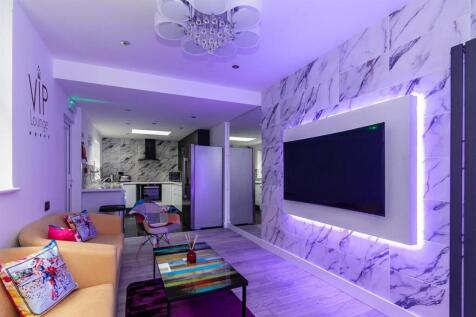 Modern lounge with large TV and marble wall...