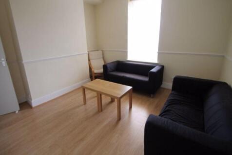 A well-lit, tidy living room featuring two comf...