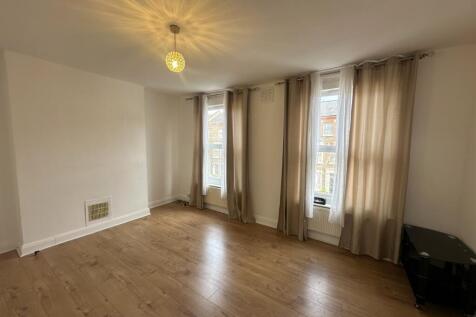 Bright living room with tall windows and woodfl...