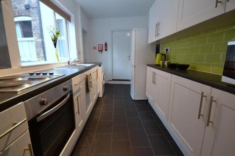 Modern kitchen with bright green splashback...