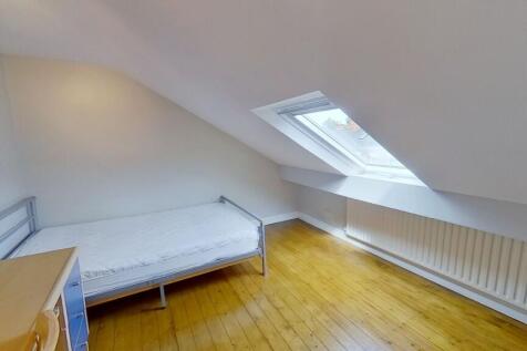 Bright attic single bedroom with a sloped ceili...
