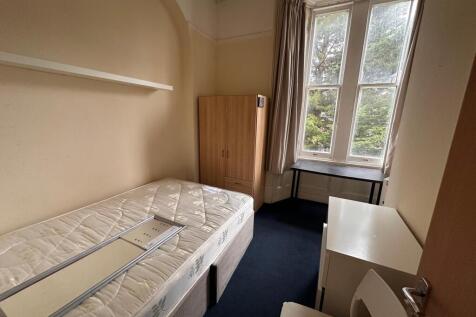 Bright single bedroom with a large sash window,...