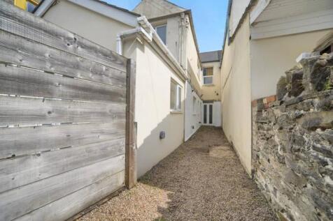 Bright gravelled outdoor space with stone walls...