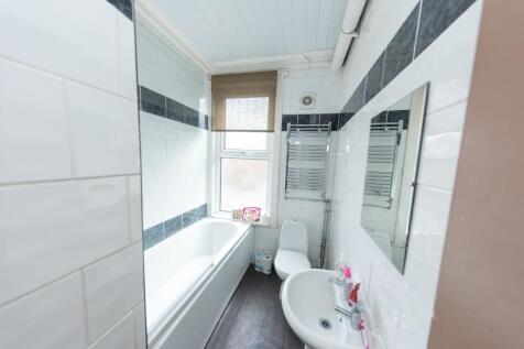 Bright and tidy bathroom featuring a large bath...