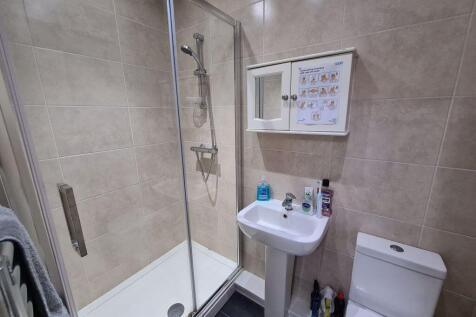 Modern bathroom featuring a glass-enclosed show...