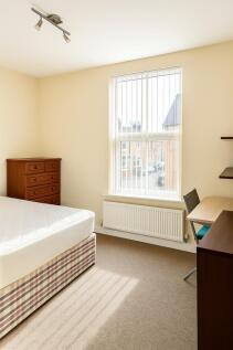 Bright, neutrally decorated bedroom with a larg...