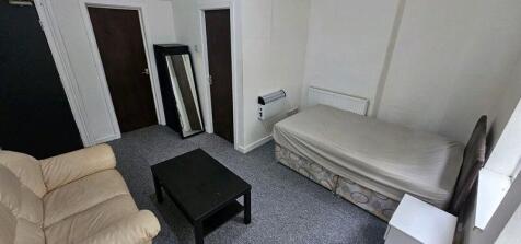 Simple furnished room with a single bed, sofa, ...