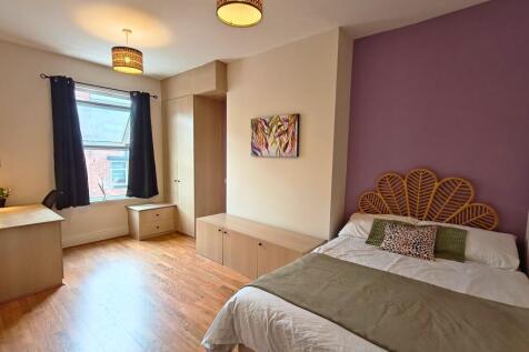 Bright, well-presented bedroom with warm wood f...