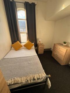 Cozy single bedroom featuring a comfortable bed...