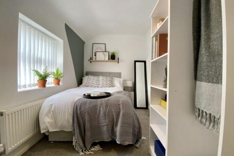 A bright and inviting double bedroom with styli...