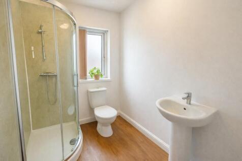 Bright modern bathroom with shower and wood flo...