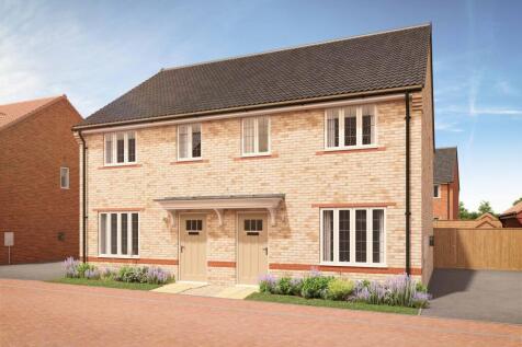 A pair of modern semi-detached houses with light brickwork and light-colored doors stand in the fore