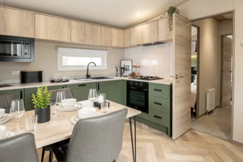 Modern Dining Area And Green Fitted Kitchen In The