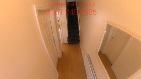 Bright narrow hallway with wall mirror...