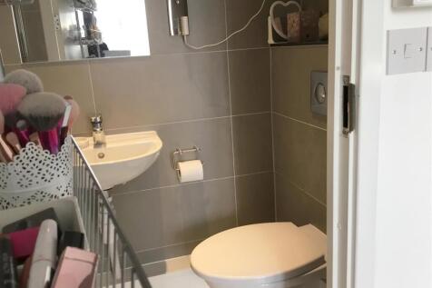 Modern tiled bathroom with wall-hung toilet and...