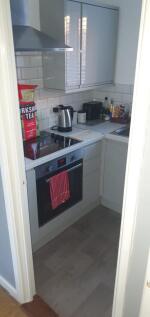 Compact modern kitchen with integrated oven and...