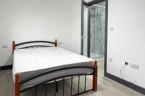 Bright, simply furnished bedroom with a double ...