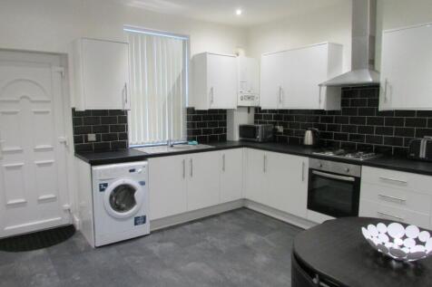 Bright modern kitchen with white cabinets, blac...