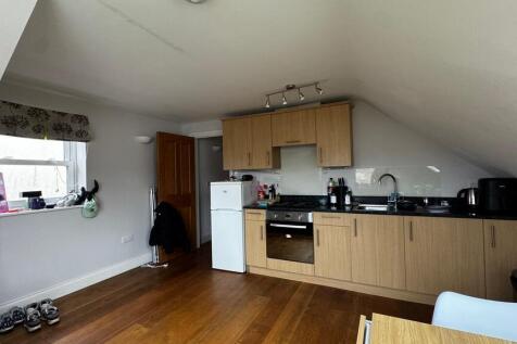 Modern attic kitchen with sleek wooden flooring...