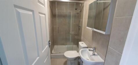 Modern tiled bathroom with a combined shower-ba...