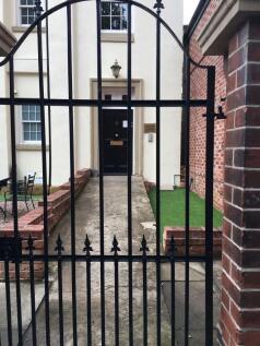 Gated entrance leading to a classic front door ...