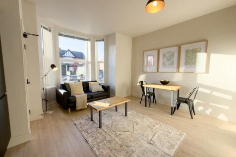 Bright, modern living room with large bay windo...