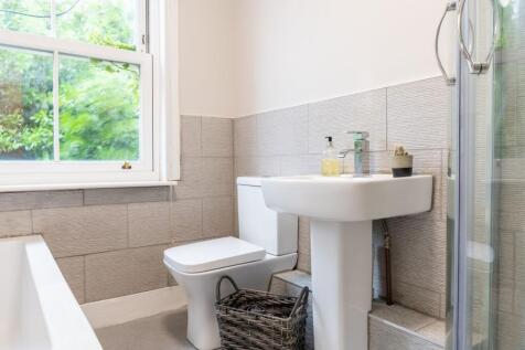 Bright, modern bathroom with a pedestal sink, t...