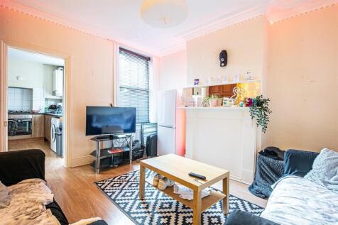 Bright living room with feature fireplace and T...