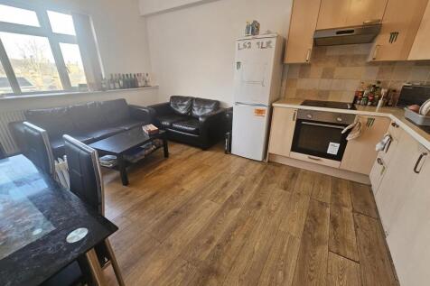 Open-plan kitchen and seating area with wood-ef...