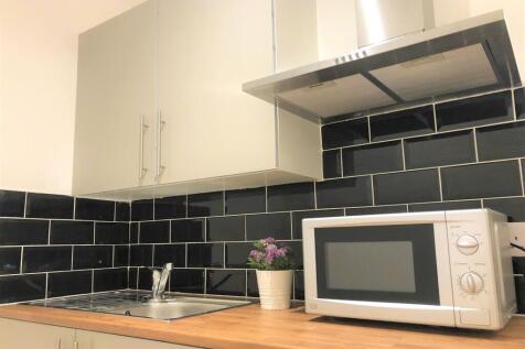 Modern kitchen featuring sleek black subway til...