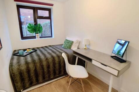 A cozy single bedroom featuring a comfortable b...