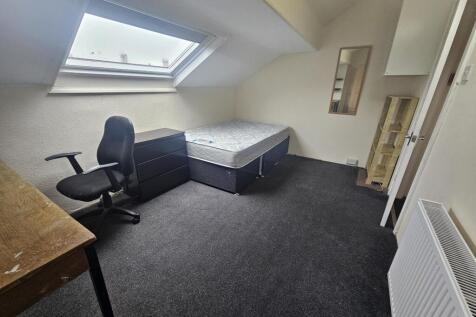 A bright and tidy living room with a large wind...