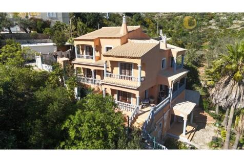 Aerial view of multi-storey villa surrounded by greenery