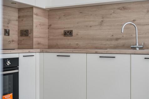 Modern kitchen with sleek wood-finish splashbac...