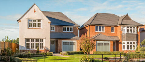 Two modern detached houses with brick and white cladding, surrounded by a well-maintained garden and