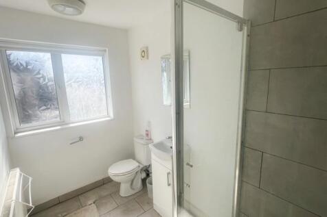Bright bathroom with large window and glass sho...