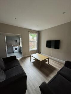 Well-presented living room with wall-mounted TV...