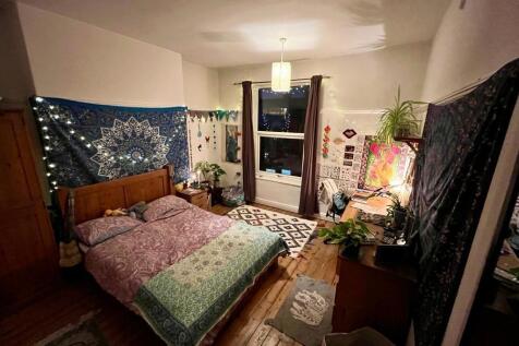 Warm, characterful double bedroom with wooden f...