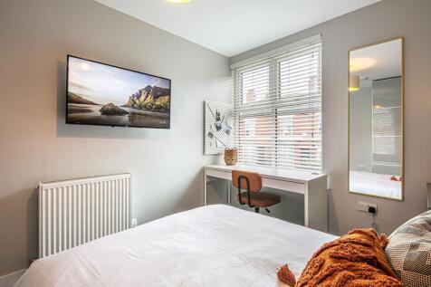 Bright and welcoming double bedroom featuring a...