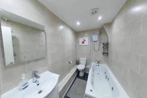A spacious and well-lit large bathroom featurin...