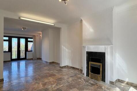 Spacious lounge with elegant fireplace and door...
