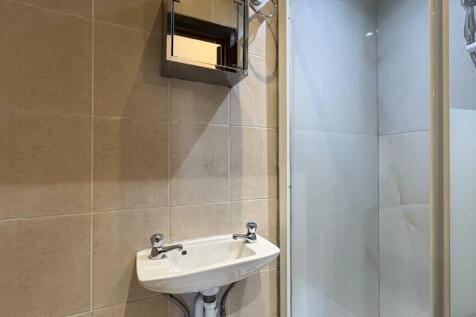 Modern tiled bathroom with a sleek shower cubic...