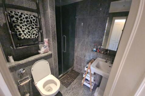 A clean and modern bathroom featuring a toilet,...