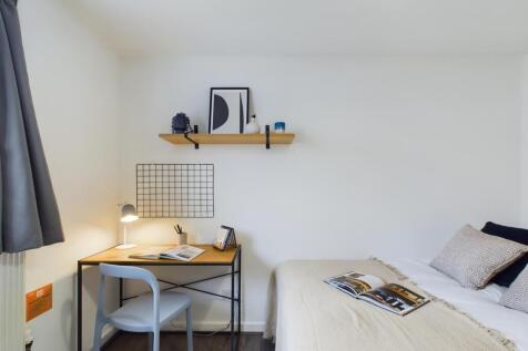 A bright and inviting small bedroom featuring a...