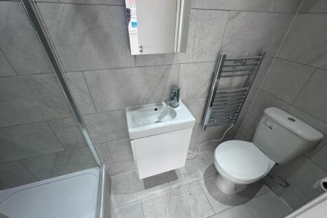 Modern tiled bathroom with a corner shower, com...