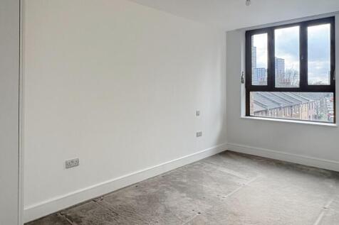 Bright, neutral bedroom with a large window off...