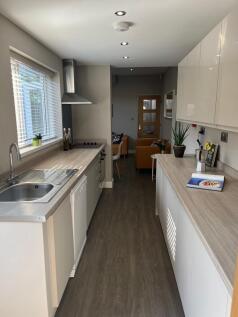 Bright, modern galley kitchen with light wood-e...