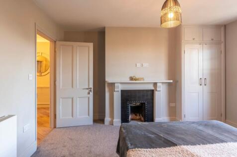 Elegant bedroom with fireplace and ample storag...