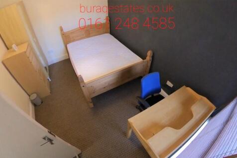 A clean and neat single bedroom featuring a woo...